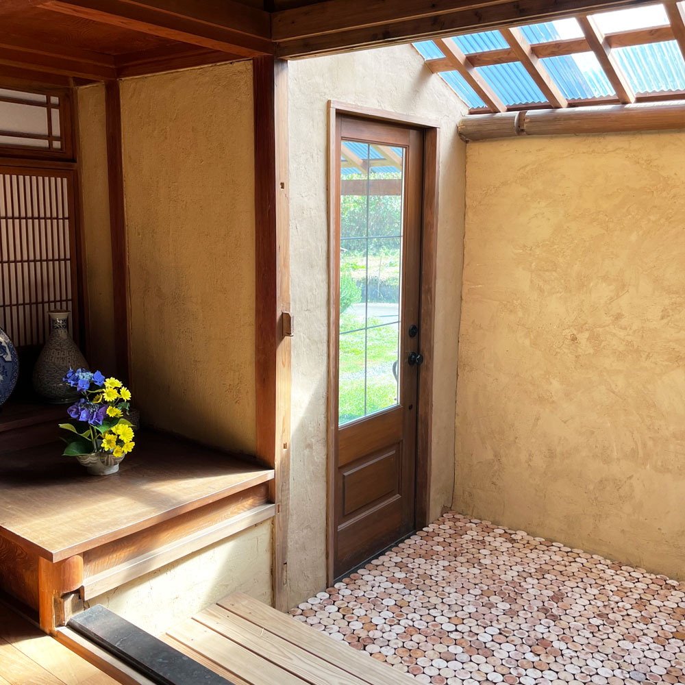 古民家リノベーションの玄関：土壁とアイアン格子の調和