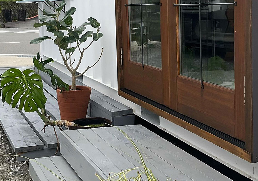 コンテナ建築と木製ドアのコントラスト