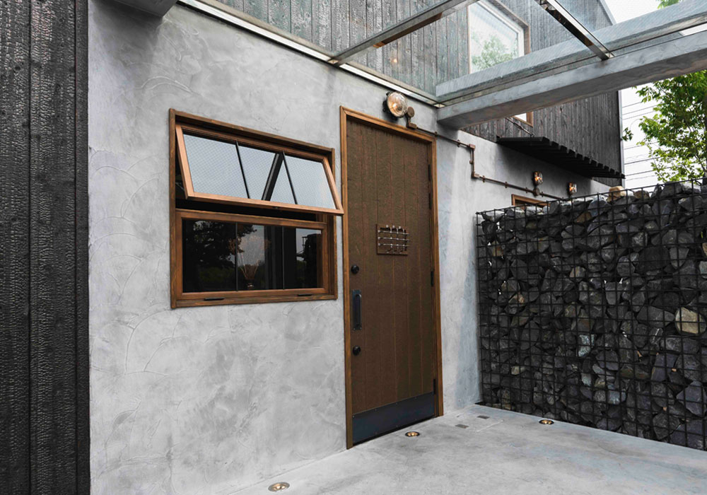 焼杉の外壁とヘビーヴィンテージ仕上げの木製玄関ドア
