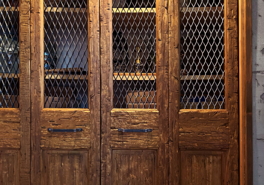 ヘヴィーヴィンテージ仕上げの木製折れ戸とメタル格子の組み合わせ