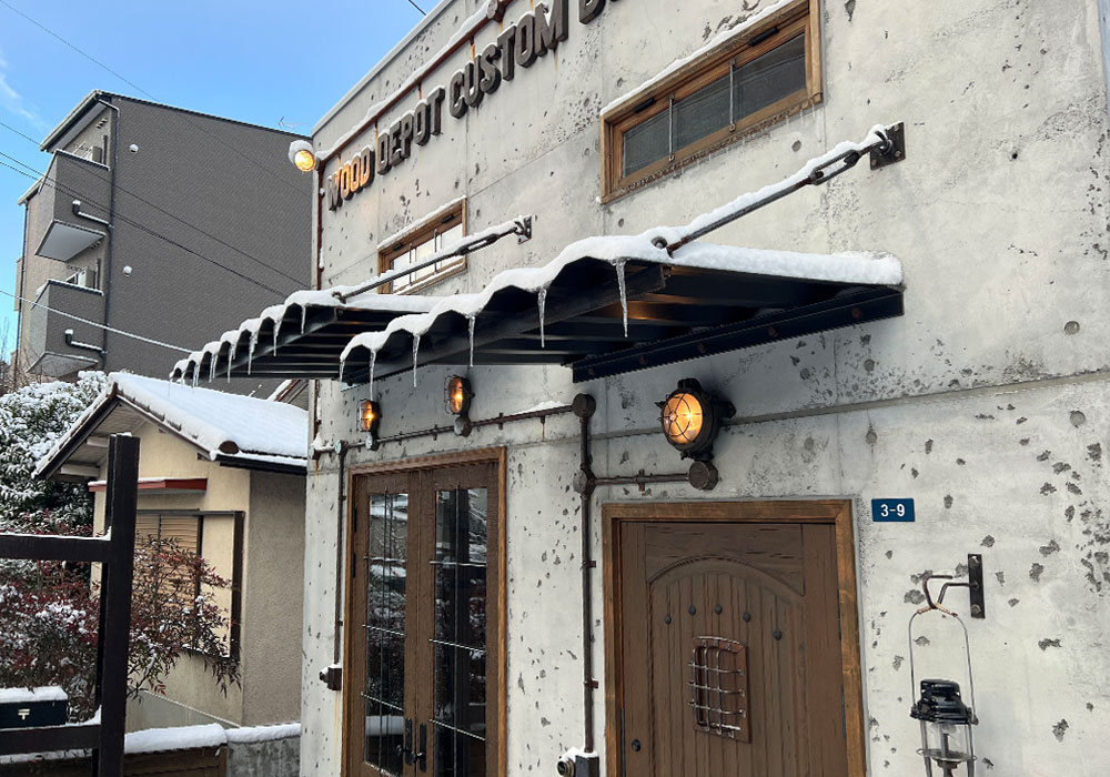 雪に包まれたショールームと木製ドアのコントラスト