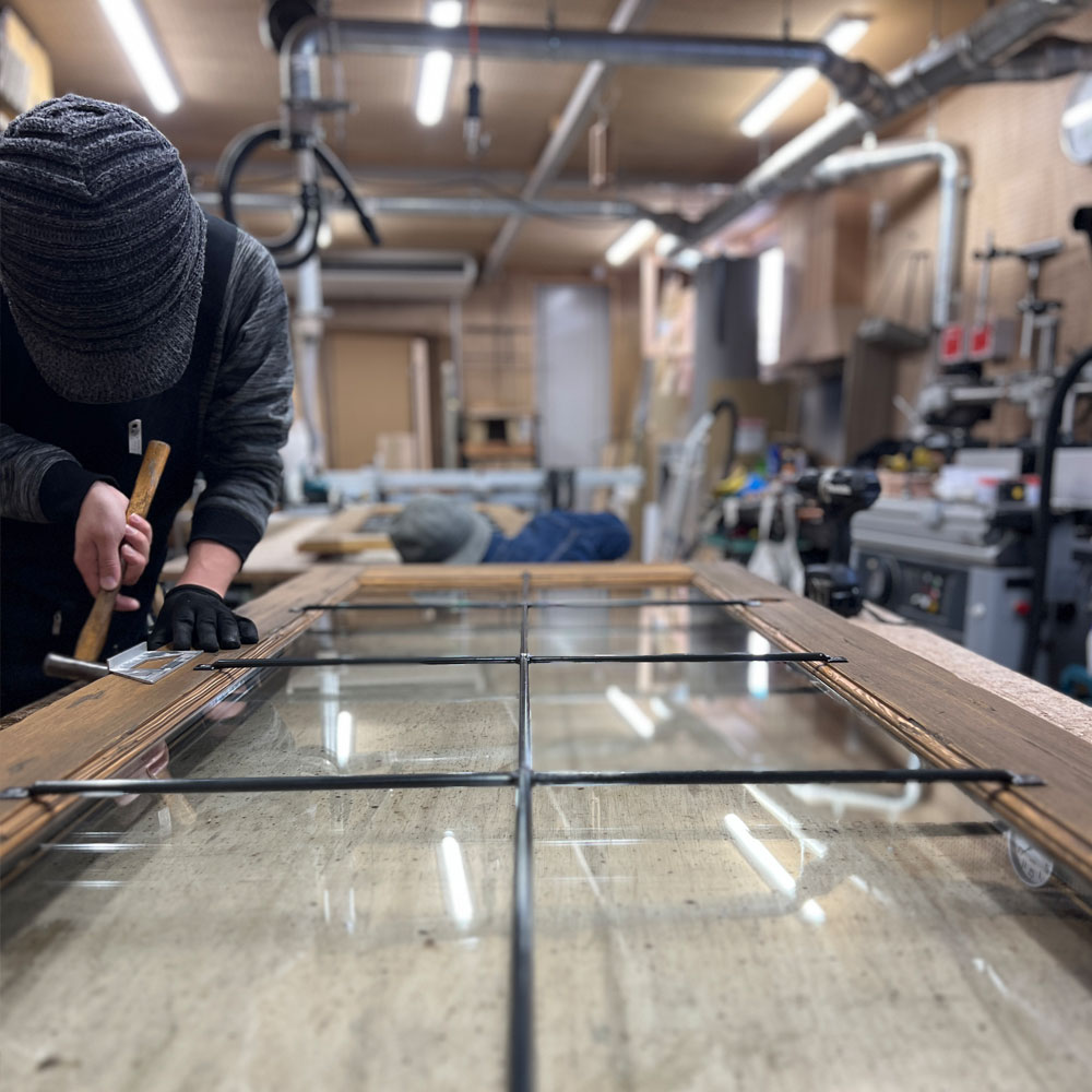 職人が真鍮銘板を丁寧に取り付ける手元のアップ