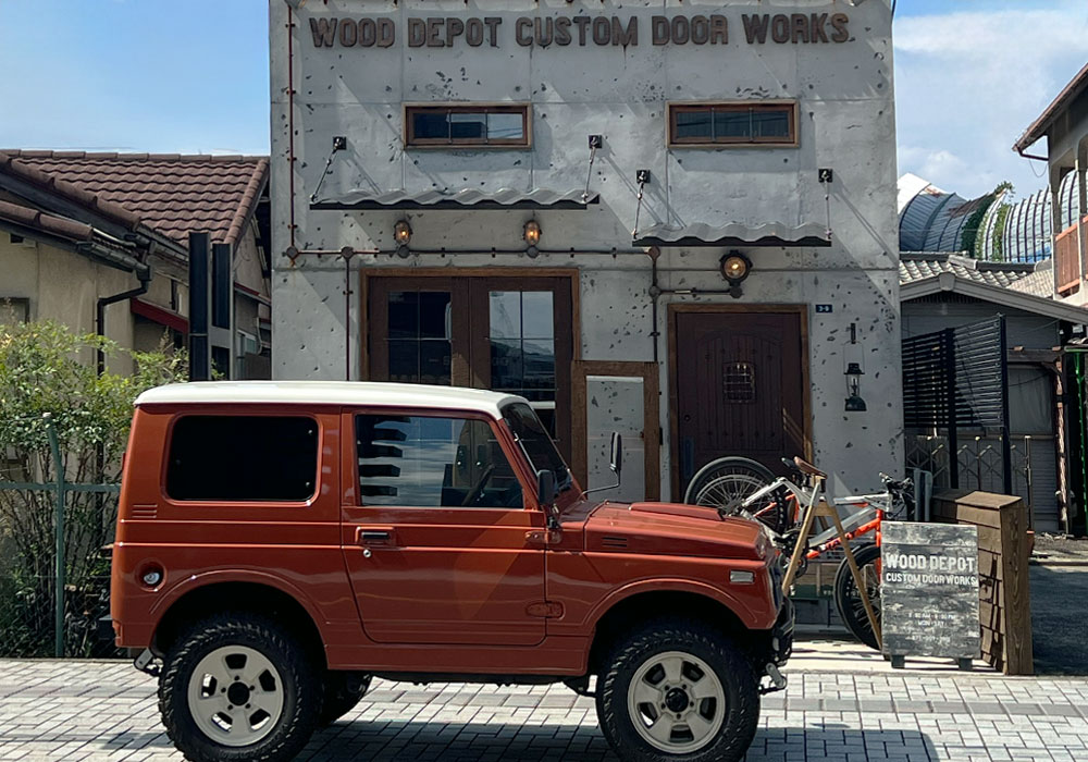 こんにちは、木製ドアコンシェルジュの北村です。:ショールーム前に停まる旧車のジムニー
