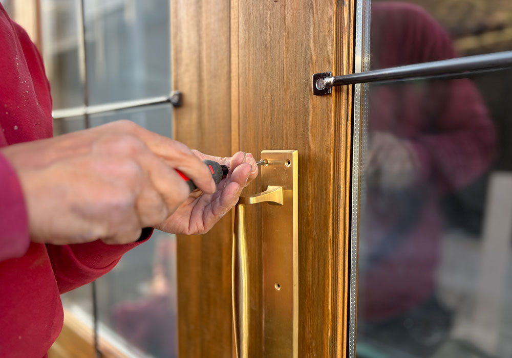 3. 現場に響く、職人の鼓動:取り付けられたばかりの真鍮ハンドルと木製ドアの質感