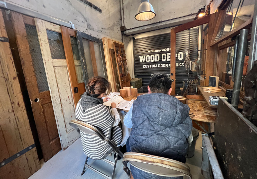 街の「ほっこり」をデザインする、入り口の役割:ショールームで提案書を広げての打ち合わせ風景