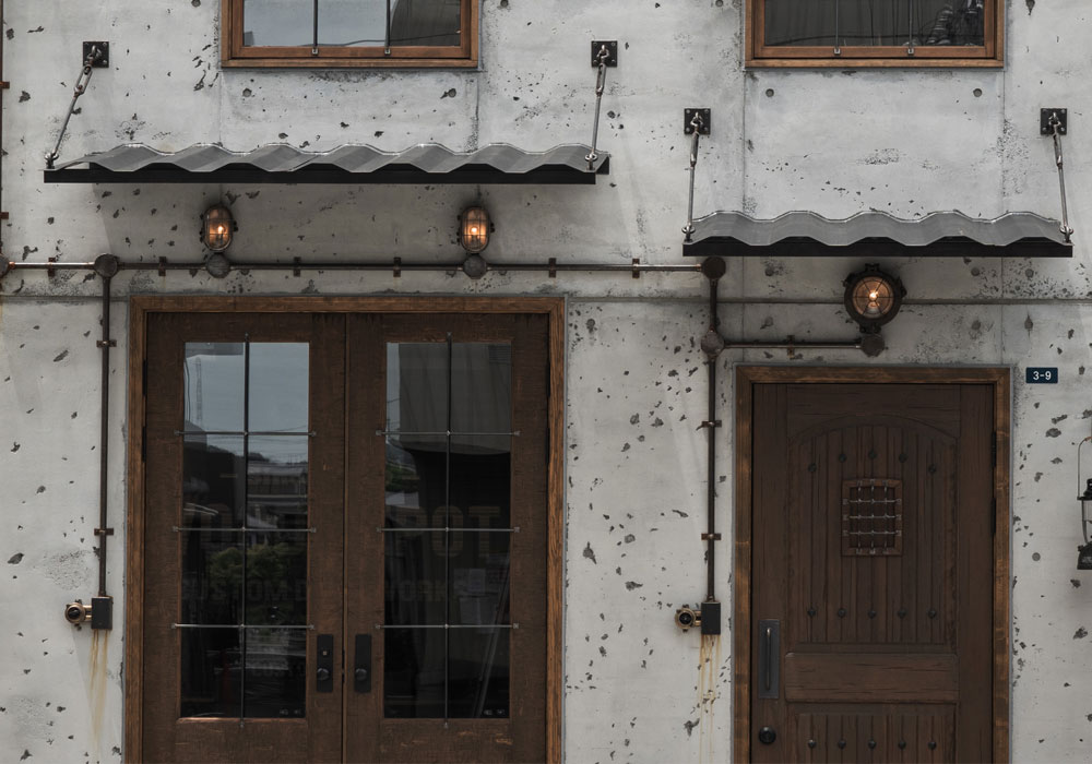 店構えの完成：木製玄関ドアとインダストリアルな庇の調和