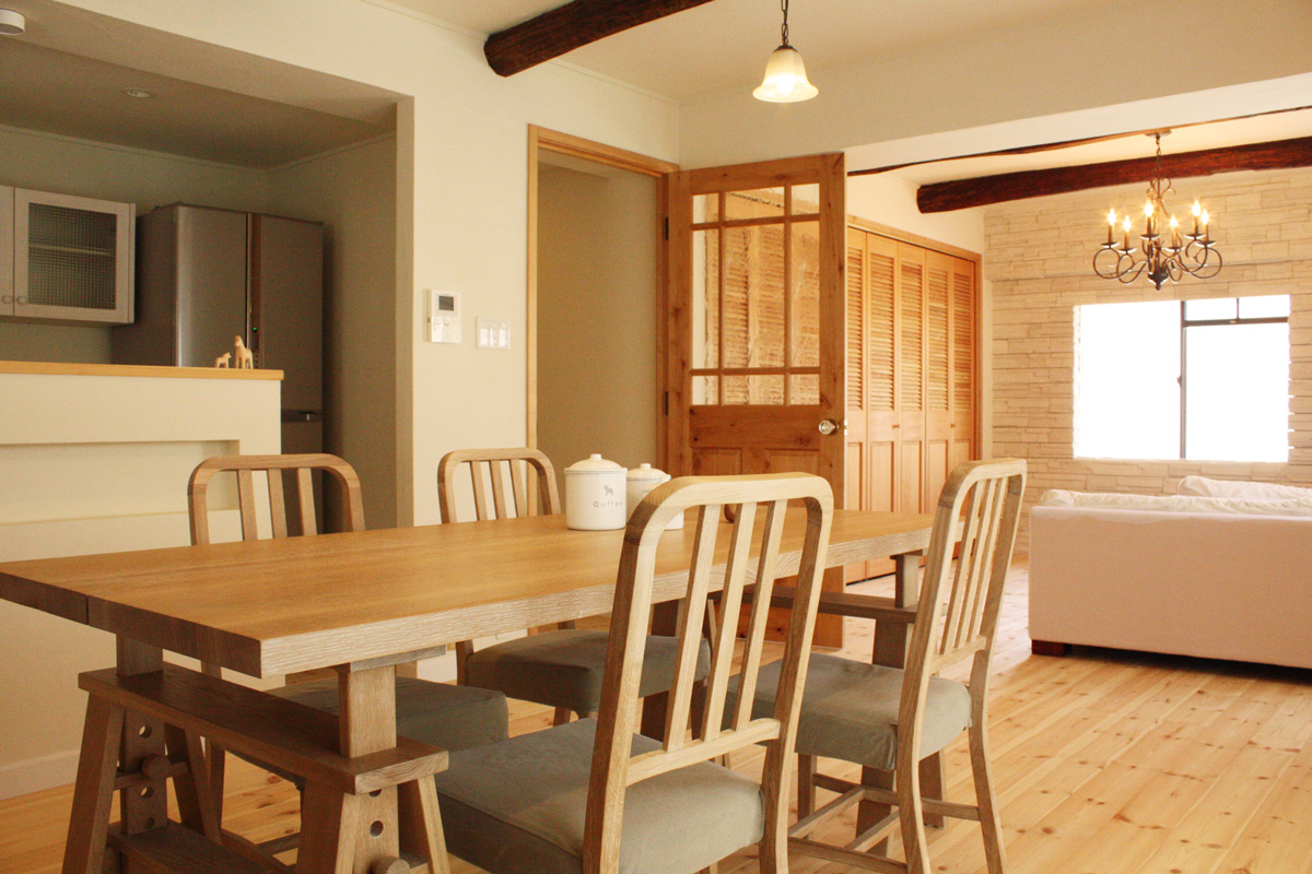 LDK全景:珪藻土の壁・パイン無垢フローリング・WOOD DEPOTのドアが調和した自然素材の空間