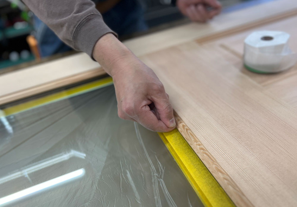 テープを指で押さえて密着させる