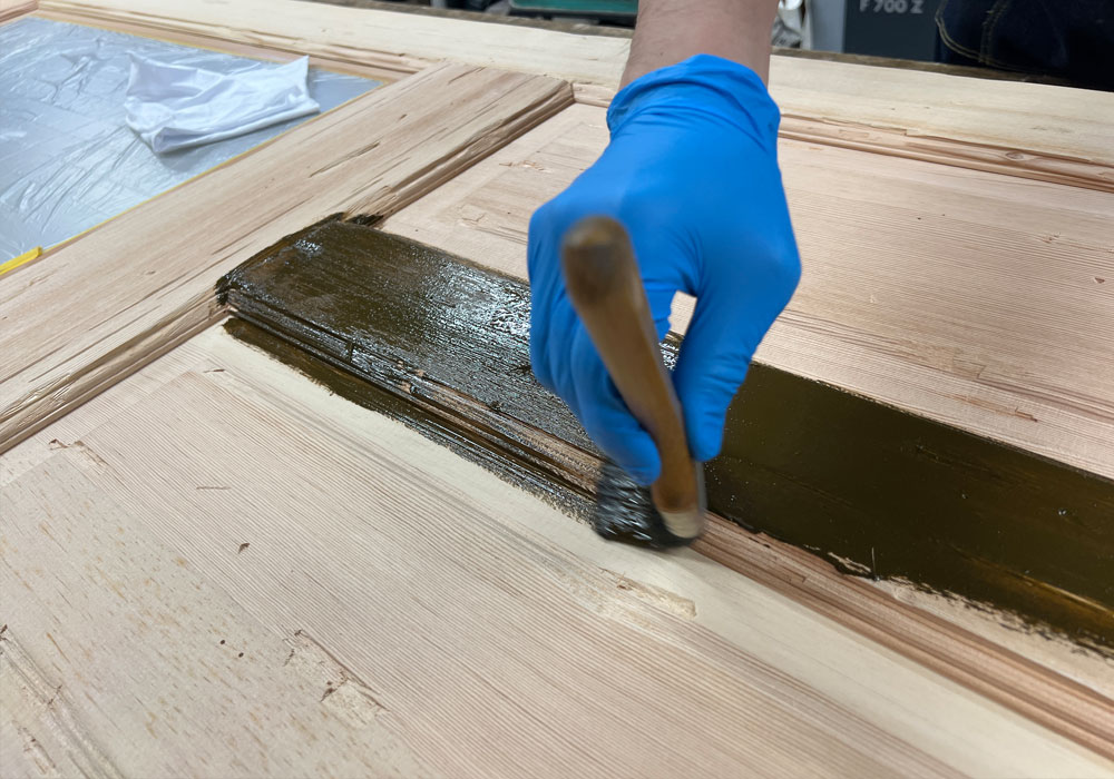 木目に沿って塗料を塗る様子