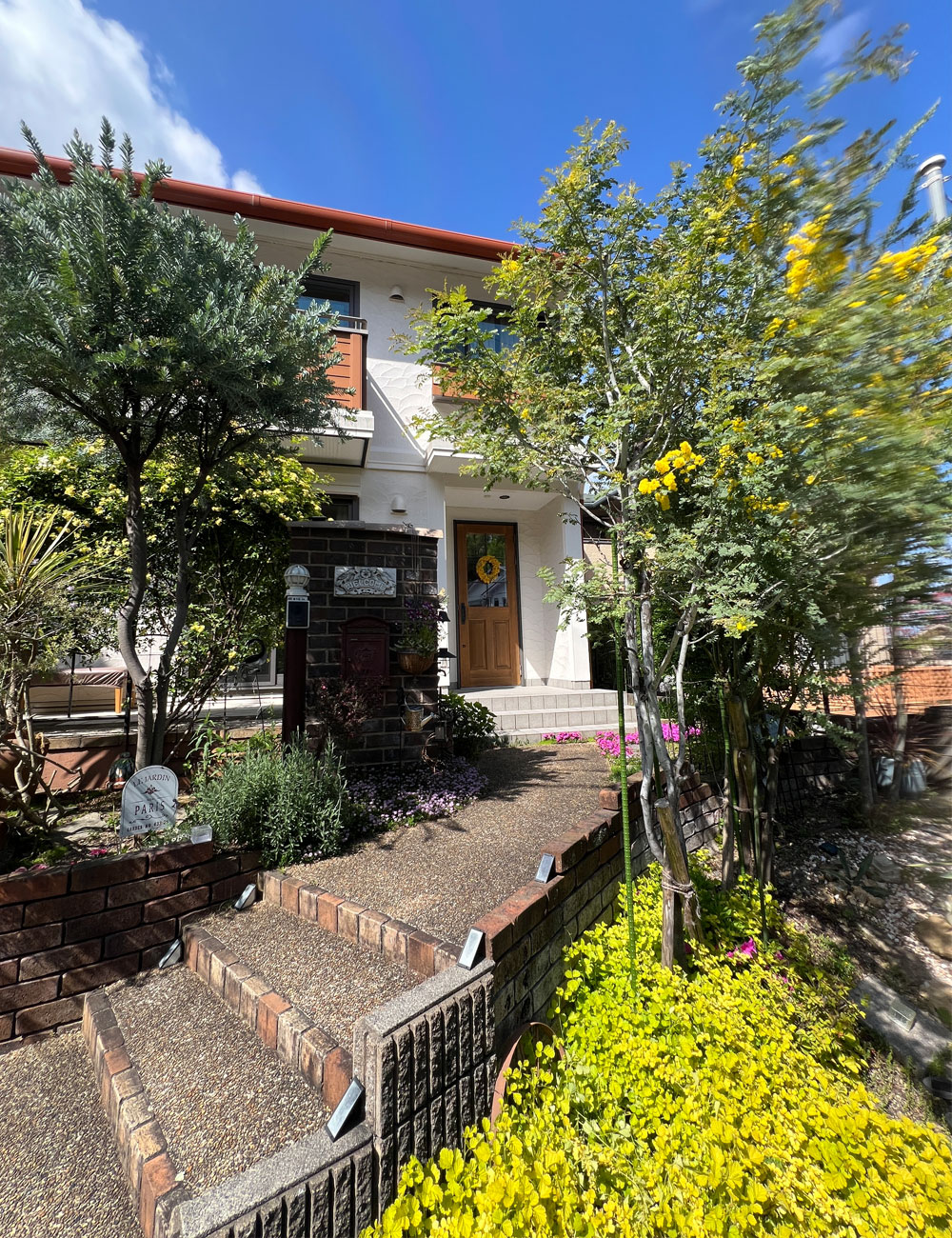 リノベーション後の玄関：アイアン格子付き木製ドア