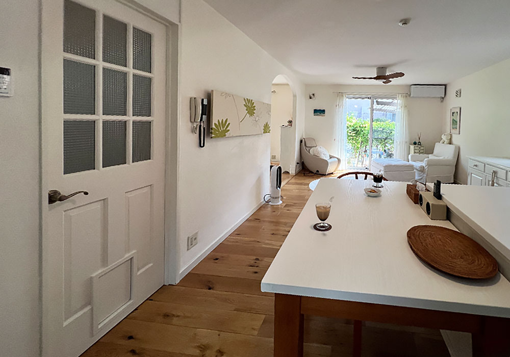 リビングから望む庭の緑と木製ドア