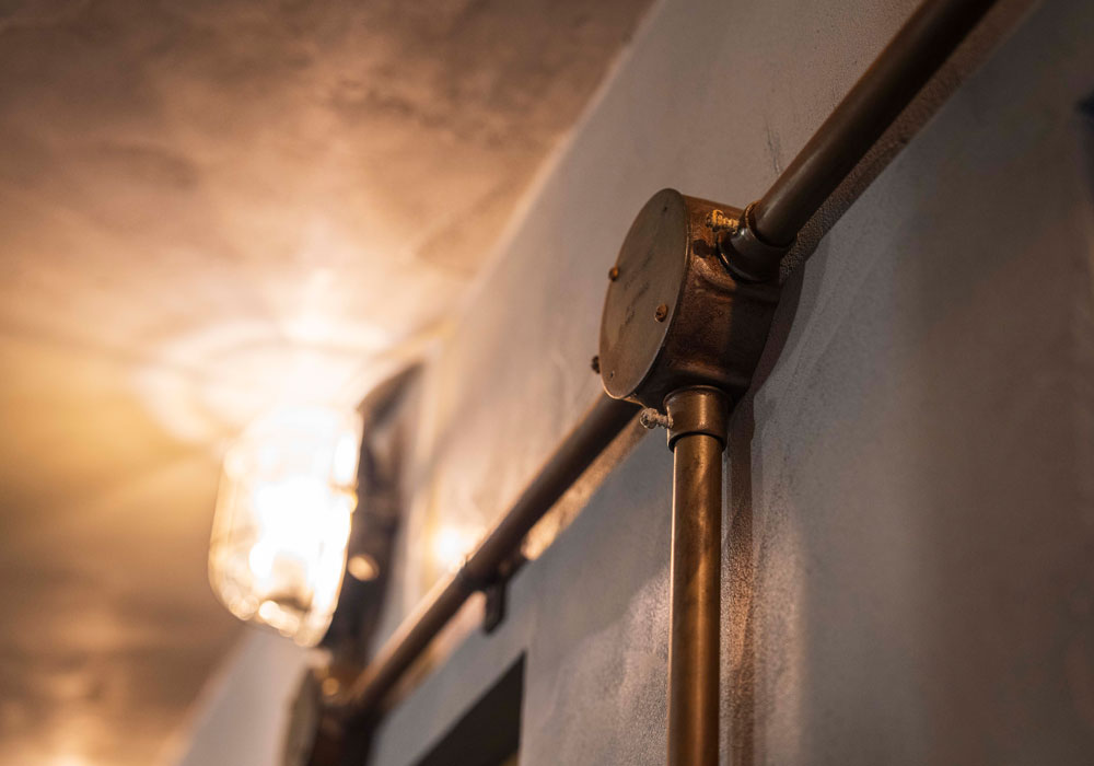 錆処理を施し深い渋みをまとった、電気露出配管の質感