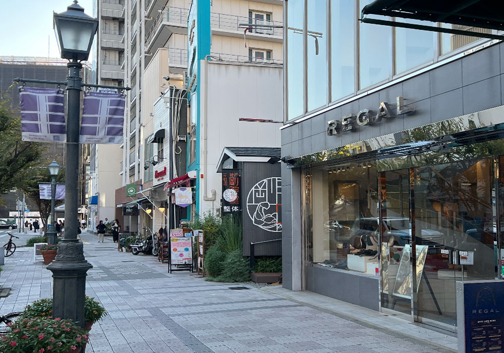 高級ブティック街に溶け込む、トレーラーハウスの店舗デザイン シックな黒のガルバニウム外壁が目を引く店舗外観