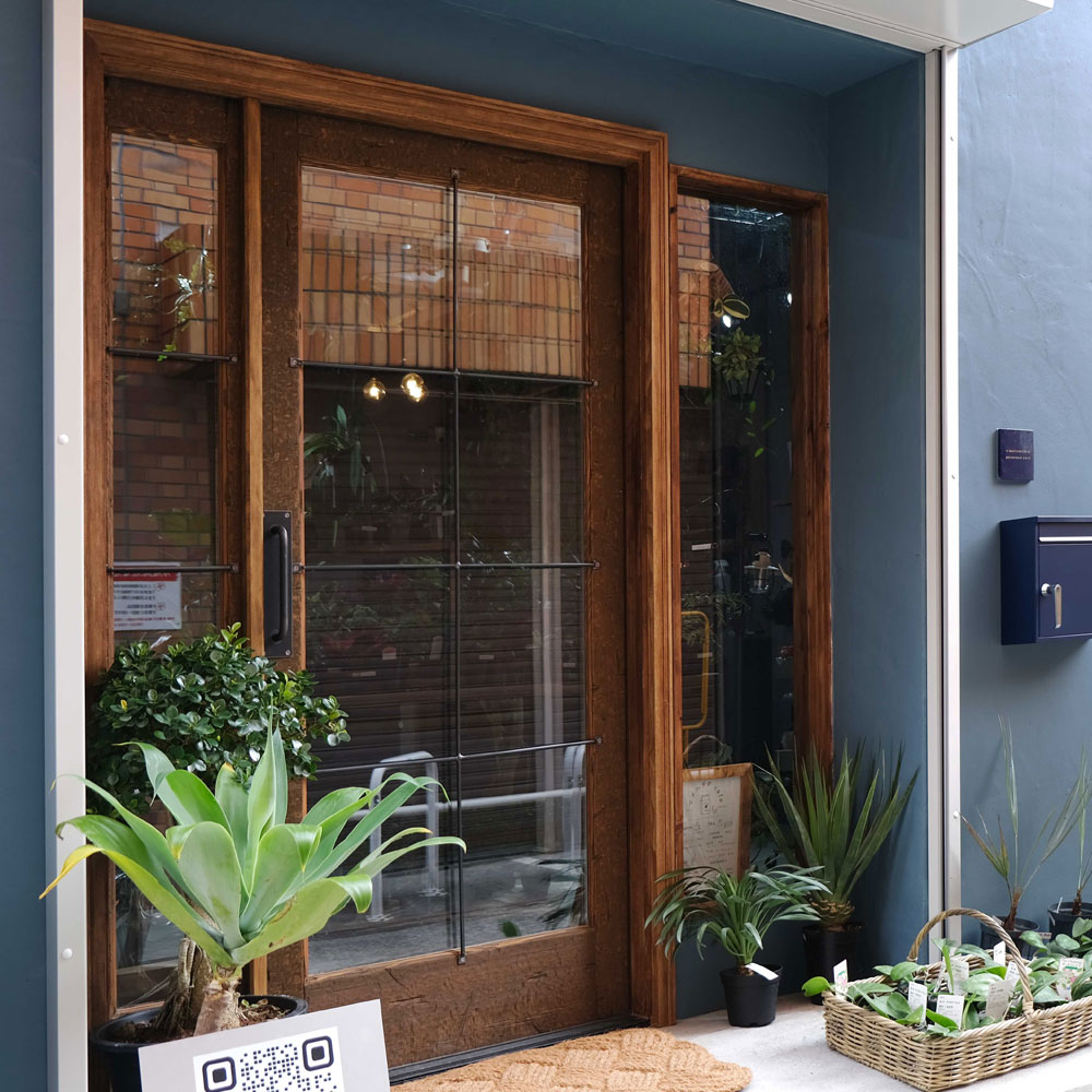 植物が際立つお店の木製玄関ドア導入事例『ヘビーヴィンテージ仕上げ』