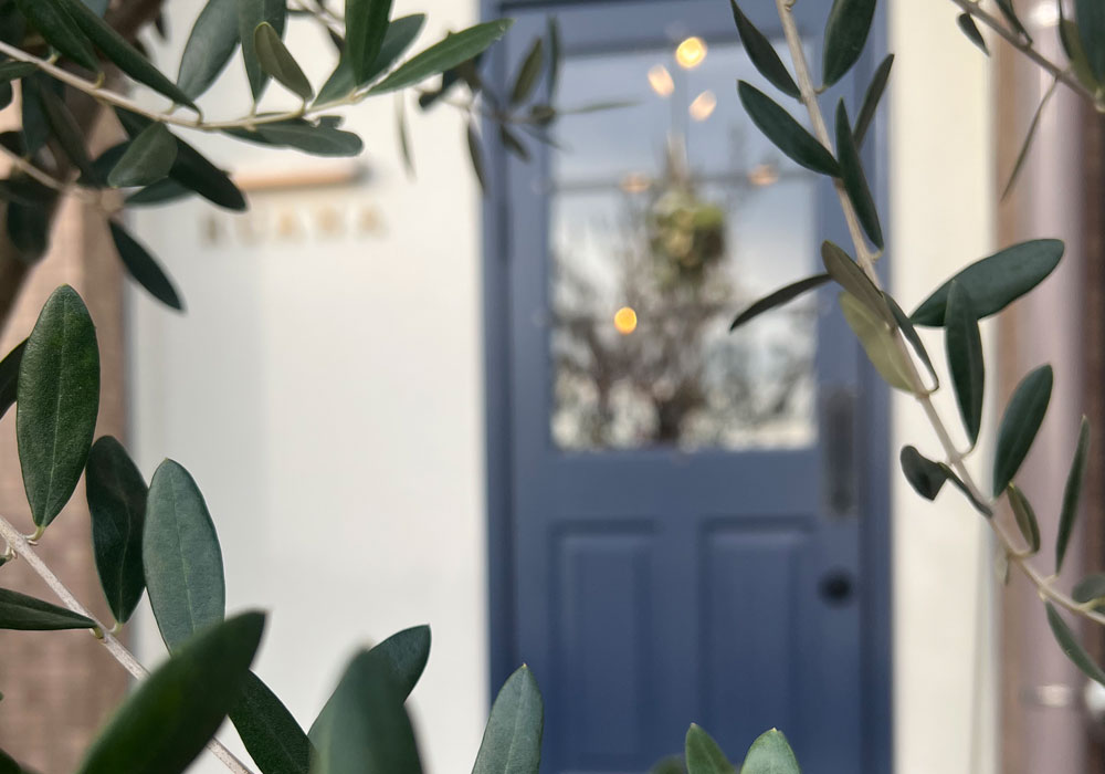 1. 玄関は「信頼」を伝える入り口 美容室の深みのあるブルーの玄関ドア