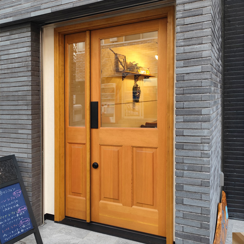 1. 道路境界線やシャッターとの干渉を防ぐ「内開き」という選択 内開きドアが設置された店舗のエントランスイメージ